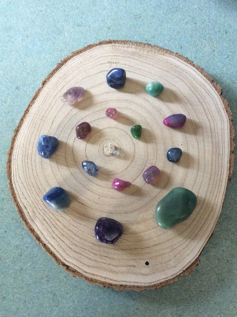 Gemstones arranged on a plaque of natural wood.